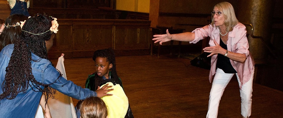expressive gesture teaching a drama class to children