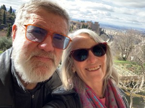 Amanda and Tim on a sunny patio with the Alhambra in the distance.