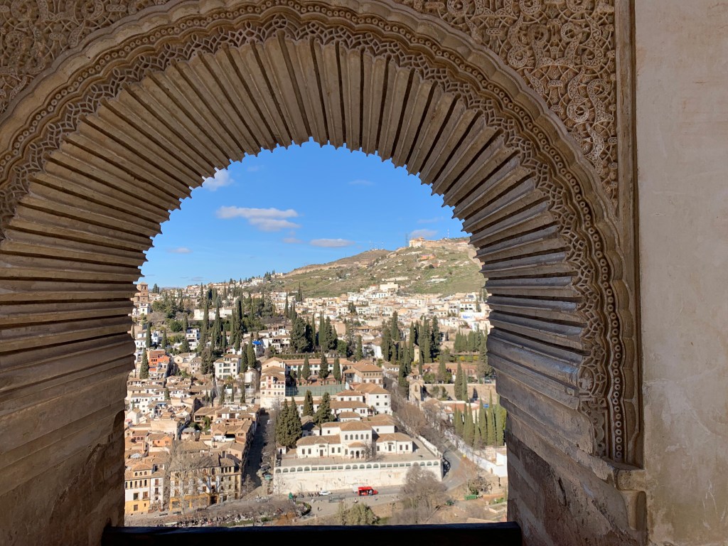 View through an arched window to the town below