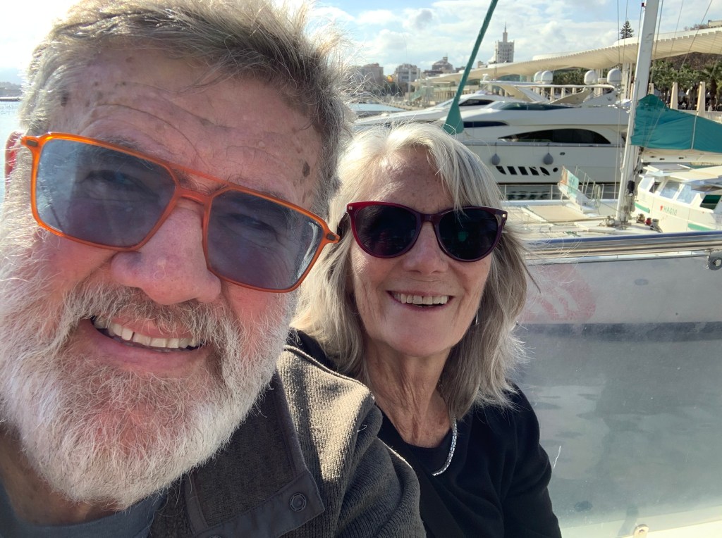  Man and woman with boats behind them.